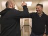 Basilio Santangelo (left) and Paul Diaz (right) high five as they pass in the hallway at The Men’s Clinic at UCLA. Along with another friend, they made appointments to get vasectomies on the same day so they could recuperate together while watching sport